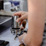 Siebträger wird mit gemahlenen Kaffee befüllt.-
